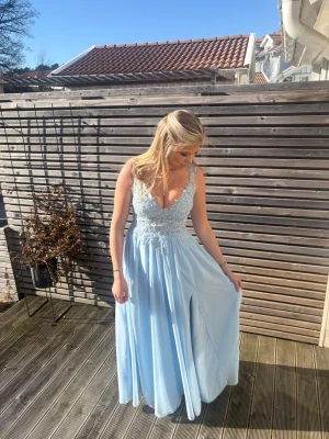 Ljusblå balklänning med glitterspets - Säljer nu min superfina balklänning från förra året! Den har oreda axelband som gör att de inte glider ner från axlarna och en inbyggd kupa så att bh inte behövs under, observera även slitsen. Inga skador och fortfarande i ett super skick! Som referens är jag 162 och brukar bära xs/s och på mig går klänningens släp till marken🤍🤍