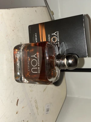 BYTE - Säljer tre parfymer: Armani Stronger With You Intensely i en stilren glasflaska med silverkork, YSL EdT i smal genomskinlig flaska och Versace i svart fyrkantig flaska med guldiga detaljer. Perfekt för dig som gillar exklusiva dofter och snygg design.