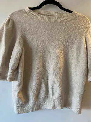 Beige stickad tröja från Vero Moda - Säljer en beige stickad tröja från Vero Moda med korta puffärmar och rund halsringning, välanvänd därav priset!!💓💓💓