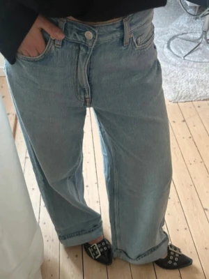 Arket jeans  - Säljer ett par ljusblåa wide leg jeans med hög midja och klassisk femficksmodell. Jeansen har raka, vida ben och är tillverkade i ett mjukt denimtyg. Perfekta för en avslappnad och trendig look.