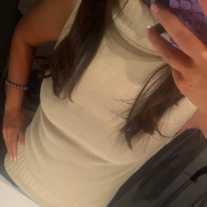 Beige ärmlös polotröja från B-Young - Säljer en beige kortärmad stickad topp med krage. Passar bra med jeans eller kjol. Har ett hål vid axeln (se sista bilden)