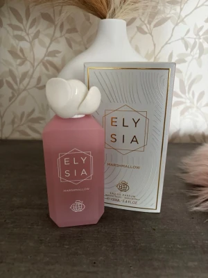 Elysia Marshmallow Eau de Parfum - Eau de Parfum från Elysia i doften Marshmallow. Flaskan är matt rosa med en unik vit dekorativ kork som liknar en blomma. Kommer i en elegant vit och guldig förpackning. Perfekt för dig som gillar söta och mjuka dofter.