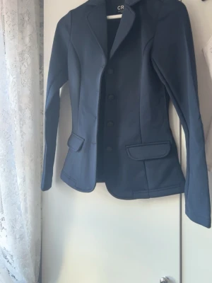 Mörkblå kavaj från CRW, stl 34 - Snygg mörkblå ridkavaj ifrån CRW. Endast andvänd en gång. Inte tvättad men kommer givetvis tvättas innan frakt🥰Nypris 800kr. Pris kan diskuteras💖
