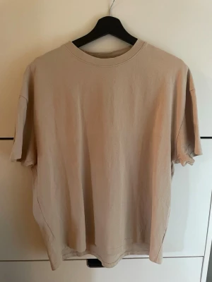 Beige t-shirt med tryck - Beige t-shirt i bomull med rund hals och korta ärmar. På ryggen står texten 'Heaven's not that far away' i svart, rött och blått. T-shirten har en relaxed passform.