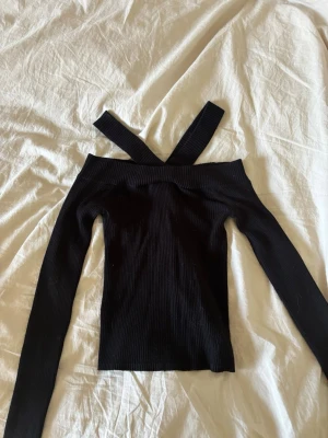 Långärmad unik topp med öppen rygg - Söt svart topp från river Island med öppen rygg med knyt, och unik off shoulder modell!