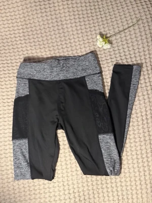 Träningsleggings från SHEIN S/36 - Snygga leggings från SHEIN i gråmelerat och svart. Hög midja och bred linning för extra komfort. Tillverkade i stretchigt material som passar perfekt till träning eller chill. Storlek S.