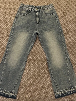 Grå raka jeans med tvättad look - Snygga grå jeans med rak passform och klassisk femficksdesign. Jeansen har en tvättad effekt som ger en cool vintagekänsla. Perfekta att matcha med sneakers och hoodie för en avslappnad stil.