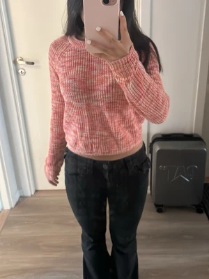 Rosa stickad tröja från ONLY - Säljer en söt rosa stickad tröja från ONLY i storlek XS. Tröjan har långa ärmar och ribbade muddar. Färgen är en mix av rosa, orange och vitt som ger en fräsch vibe. Perfekt till jeans eller kjol! Säljer för den inte kommer till användning 