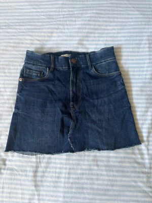 Mörkblå jeanskjol  - Säljer en mörkblå jeanskjol från Lindex, knapps använd!! Perfekt för sommaren, mycket fin!! 