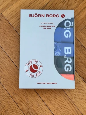 5-pack kalsonger Björn Borg strl 170 - Säljer ett 5-pack boxerkalsonger från Björn Borg i storlek 170. Kalsongerna är i olika färger, bland annat blå, svart och orange, och har bred resår med Björn Borg-logga. Tillverkade i mjuk bomull med stretch för extra komfort. Nypris: 549kr