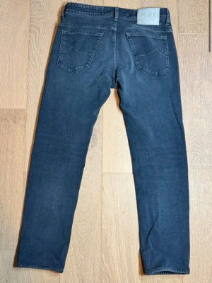 Jacob cohen jeans - Snygga mörkblå jeans från Jacob cohen med klassisk femficksdesign och diskreta slitningar. Jeansen har normal midja, raka ben och är tillverkade i mjukt denimtyg med lite stretch för extra komfort. Perfekta för en avslappnad och trendig look.
