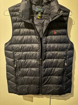 Polo Ralph Lauren väst  - Hej! Jag säljer nu min Polo Ralph Lauren väst i 9/10 skick. Den är bara använd några enstaka gånger. Jag säljer den pga av att den är för liten för mig. Sizen är 14-16 år, vilket motsvarar ungefär XXS-XS. Om du är intresserad eller har några frågor är det bara att kontakta mig, så ska jag besvara dina frågor och funderingar så bra jag kan. Mvh