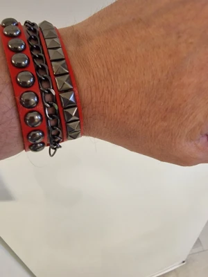 Armband punk röd - Armband punk röd. 22 cm långt. Bredd 3cm. PU läder.