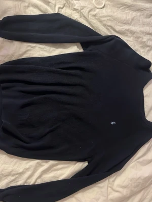 Mörkblå tröja från Ralph Lauren - Snygg mörkblå tröja från Ralph Lauren med klassisk broderad logga på bröstet. Tröjan har rund halsringning och långa ärmar, perfekt för en stilren och enkel look. Hör av er vid frågor!