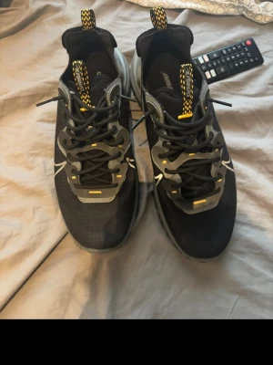 Nike D/MS/X svarta sneakers - Svarta Nike D/MS/X sneakers med grå och gula detaljer, coola snörningar och tydlig Swoosh-logga på sidan. Ovandelen är i mesh och syntetmaterial för en sportig vibe. Sulan är robust och designen har en modern streetkänsla. Perfekta för dig som gillar stilrena men ändå unika sneakers.