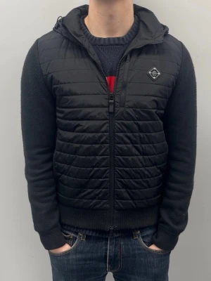 J.Lindeberg hybrid cardigan - Små defekter på vänstra sidan av jackan men inget man ser på avstånd, annars är den väldigt fint skick. Modellen är 185 cm lång och väger ca 78 kg.
