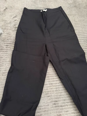 Svarta vida byxor från NLY Trend - Säljer ett par svarta byxor från NLY Trend i storlek 32. Byxorna har hög midja och vida ben, vilket ger en avslappnad och trendig look. Materialet känns mjukt och stretchigt, perfekt för dig som gillar stilrena och bekväma plagg.
