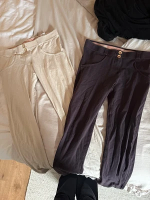 Freddy WR.UP byxor i beige och brun🩷 - Två par Freddy WR.UP byxor, ett par i beige och ett par i brun. Båda har mid waist/ low midja, dubbla knappar och stretchigt material som formar sig efter kroppen. Perfekta för dig som vill ha bekväma och snygga byxor med shaping-effekt. Säljer båda två för 599kr🩷funkar också som ridbyxor🩷