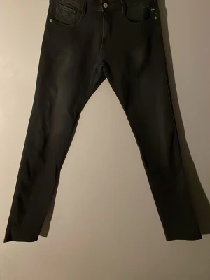 Svarta slim fit jeans från Replay - Ett par helt oanvända svarta Replay Anbass Power Stretch med lappar kvar🤩. Storlek W33 L34 perfekt för dig som är 185-195 cm😎. Nypris 1200kr, mitt pris 600kr men är öppen för förhandling. Säljer för att det inte är min stil riktigt.