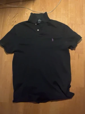 Svart piké från Ralph Lauren - Säljer denna svarta pikétröja från Polo Ralph Lauren. Den är i bra skick, har använts men inga tydliga hål eller så alls. Den är i storlek S men passar även XS skulle jag nog ändå säga. Priset kan absolut diskuteras, vill helst bara bli av med den då jag växt ur den.
