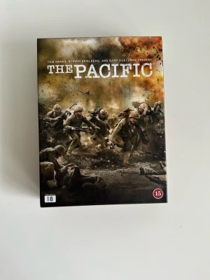 The Pacific - DVD-box - komplett miniserie  - DVD med bejublade ”The Pacific”, en miniserie i tio delar som utspelar sig under andra världskriget. Serien följer tre amerikanska marinsoldaters upplevelser i Stillahavskriget. Producerad av Tom Hanks, Steven Spielberg och Gary Goetzman. Denna utgåva innehåller sex skivor med alla tio avsnitt samt extramaterial som "Profiles of the Pacific", "Making the Pacific" och "Anatomy of the Pacific War". Ljudspår finns på 8 språk och undertexter på 17 språk (inkl svenska). Originalförpackning.