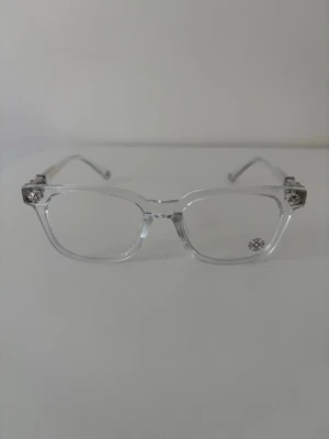 Transparenta solglasögon med silverdetaljer - Snygga solglasögon med transparent båge och rektangulär form. Bågarna har coola silverdetaljer vid gångjärnen som ger en unik touch. Perfekta för dig som vill ha en clean och modern stil. Lätta att matcha med olika outfits.
