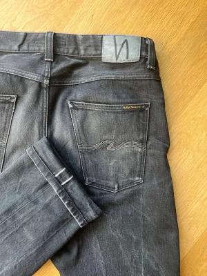Nudie Selvege limited edition L36 - Dem är i model Gritty Jackson en straight cut. Dessa är jätte unika svarta selvege jeans från Nudie. Dem har en jätteovanligt gradient design på bakfickan och har svart selvege ID. Om du kan lite mer om svart selvege så fadar det långsammare och dessa har andvända i cirka 3 år med ~5 tvättar men nu är dem nytvättade. Måtten finns på nudies hemsida. W34 L34. Passar dig runt 190 cm och 80-85 kg typ inte exakt. Dem sitter fint på skorna. 
