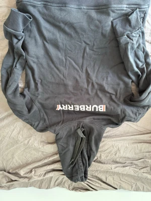 Burberry hoodie - Svart burberry hoodie som ej används längre. Köpte den för något år sedan men har inte användit den på ett bra tag och därför säljer jag den. Dene plain and simple så som man ser på bilden med en svart baksida