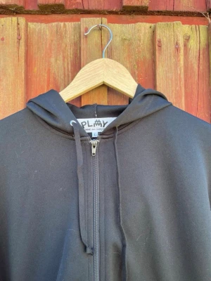 Comme des Garçons PLAY x Invader Zip Hoodie - Sällan använd svart Comme des Garçons PLAY zip hoodie från samarbetet med den välkända street art-konstnären Invader.  Storlek: Large Tillverkad i en bekväm bomulls-/polyesterblandning och i mycket fint skick med minimala bruksspår. Inköpt på Dover Street Market i London. Pris kan diskuteras.
