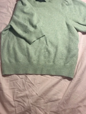 Ljusgrön stickad tröja - En super fin, gosig och strechig grön kortärmad stickad tröja från Vero Moda! Hade två små hål ( se sista bilderna ) men har syns knappt så jag handsytt det. Men säljs ändå lite billigare pga av det, annars är tröjan så gott som ny och knappt använd! 