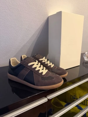 Maison margiela gats - Tjena! Säljer/byter nu mina Maison margiela gats i en brun/svart färg som jag har haft i ungefär ett halvår nu, dom är i extremt fint skick då dom har varit sparsamt använda osv. Sulan är väldigt fin den med då den inte är nedskrapad på något sätt. Box och dustbag fås givetvis med. Tar emot byten! Hör av dig om du har minsta lilla fråga eller vill ha fler bilder osv osv.