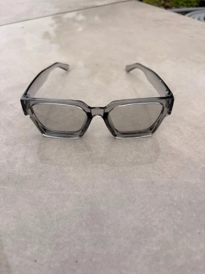 Grå fyrkantiga solglasögon - Snygga solglasögon med transparent grå båge och stora fyrkantiga glas. Ramen är chunky och ger en modern vibe, perfekt för dig som vill sticka ut. Passar till alla tillfällen där du vill ha en cool accessoar.🕶️⛱️❤️☀️