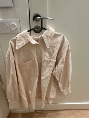 Beige overshirt från Levi's - Säljer en beige overshirt från Levi's i mjuk manchester. Skjortan har två stora bröstfickor, klassisk krage och knäppning framtill. Passformen är loose och den är perfekt att slänga över en t-shirt för en chill look.