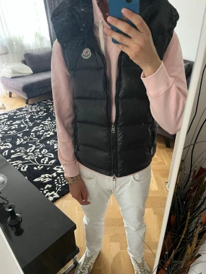 Moncler väst - Säljer min fina Moncler-väst då den tyvärr blivit för liten för mig. Västen är i mycket fint skick och knappt använd, vilket gör den till ett väldigt prisvärt alternativ.  Det är ett stilrent och mångsidigt plagg som passar perfekt under våren och hösten, men fungerar lika bra under svalare sommarkvällar.                 Hör gärna av dig vid frågor, funderingar eller om du vill lägga ett bud. Priset är inte hugget i sten.🪨😁