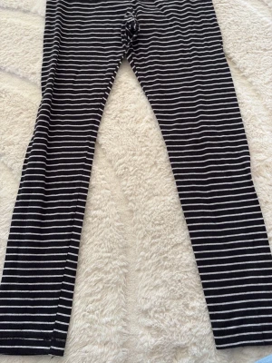 Svartvita randiga leggings H&M - Säljer ett par svarta leggings med vita horisontella ränder från H&M i storlek M. De har en klassisk, tajt passform och är tillverkade i ett mjukt och stretchigt material som sitter skönt hela dagen. Perfekta för en avslappnad och trendig look.