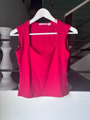 Röd ärmlös linnetopp - Snygg röd linnetopp med fyrkantig ringning och enkel design. Toppen är ärmlös och har en rak passform som passar perfekt till jeans eller kjol. Skriv för fler bilder. Tvättar såklart innan jag postar❣️aldrig använt 