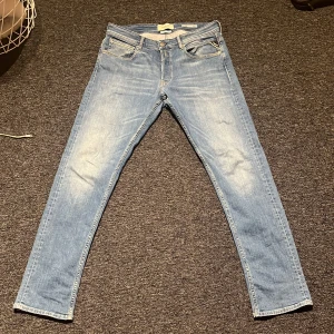 Ljusblå Replay Groover - Snygga ljusblå straight fit jeans från Replay med klassisk femficksdesign och diskreta slitningar framtill. Jeansen har normal midja, dragkedjegylf och Replay-lapp bak i midjan. Perfekta för en avslappnad och trendig look. Priset kan diskuteras!