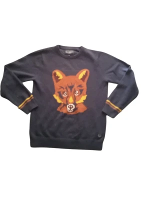 Mörkblå stickad tröja med rävmotiv - Stickad tröja i mörkblått med stort rävhuvud i orange, gult och brunt på bröstet. Långa ärmar med gula och orange ränder vid muddar. Rund halsringning och ribbade avslut. Perfekt för dig som gillar djurmotiv och vill ha en unik look.