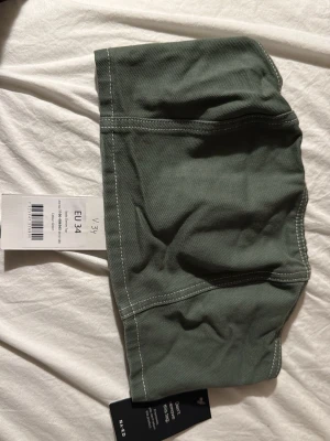 Denim tubtopp - Grön denim tubtopp från NA-KD med kontrasterande vita sömmar. Toppen är ärmlös och har en enkel, croppad passform.