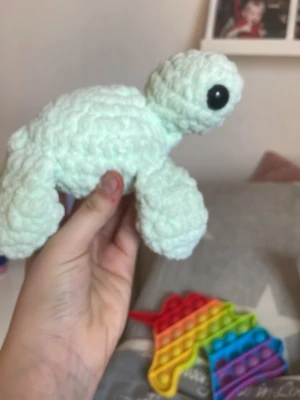 Virkad ljusgrön sköldpadda med skall  - Säljer en handgjord, virkad sköldpadda i ljusgrönt garn med  svarta plastögan. Sköldpaddan har en rund kropp och fyra ben, och är mjuk och gosig. Perfekt som dekoration eller leksak. Materialet är tjockt, fluffigt garn.