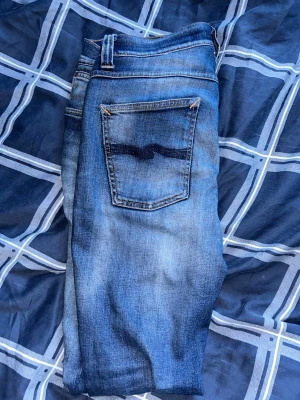 Nudie archive jeans  - Säljer dessa sjukt feta nudie jeans, de har en as fet tvätt och har åldrats bra. Kolla bild 5 för hur de såg ut innan. Modell lean Dean size 32/32  lite slitningar som är lagade. Färgen i annonsen kan avvika från verkligheten 