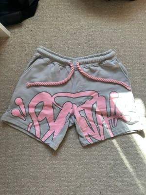 Syna World shorts - Detta är Syna World shorts ifrån Central Cee märke. Shortsen är helt nya och oanvända. Ifall du söker nånting inför sommaren är detta det perfekta valet. 