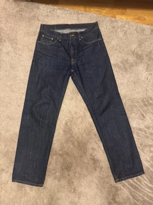 Nudie Rad Rufus One Wash - Säljer dessa riktigt snygga Nudie Rad Rufus. Färgen är One Wash och är därför ett torrt par som endast tvättats en gång innan jag köpte dem. Jag har haft de i ett par månader men tröttnade efter ett tag och slutade använda dem. Själv har jag inte tvättat de någon gång och de har därför bra möjligheter till fades i framtiden. Storleken är W30 L30 men skulle säga att de passar W31 L31. Köpte dem för 1600 och har kvitto! Mått: Midja: 41,5 cm. Ytterbenslängd: 104,5 cm. Skriv gärna frågor/prisförslag