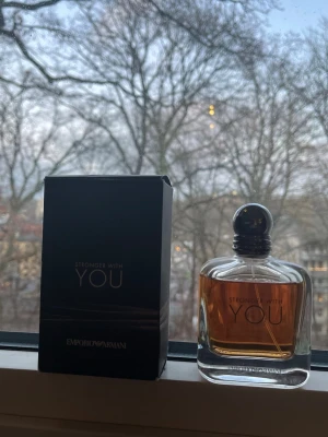 Emporio Armani Stronger With You parfym - Emporio Armani Stronger With You är en elegant parfym i en genomskinlig glasflaska med rundad form och svart kork. Doften har en varm bärnstensfärgad vätska och kommer i en stilren svart förpackning med silvertext. Perfekt för dig som gillar exklusiva dofter. Använd några gånger men som man ser på bilden är flaskan nästan full