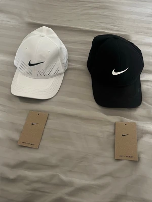 Nike Dri-FIT svart och vit keps - Två snygga kepsar nike dri fit kan vara svåra få tag på i perioder, helt ny i princip. Original pris 350.  Storlek S/M