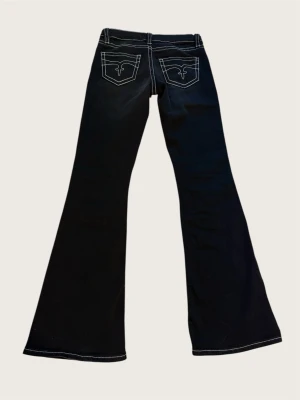 Low waist flare jeans - Så snygga svarta flare jeans från Gina. Vita kontrastsömmar och fina detaljer på fickorna. Använda kanske 5 gånger, så mycket fint skick ☺️ storlek S, 14+, Tall.