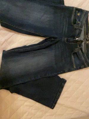 Mörkblå jeans - Snygga mörkblå jeans med klassisk femficksdesign och subtila slitningar framtill. Jeansen har kontrastsömmar och en något utsvängd passform nedtill. Perfekta för en avslappnad och trendig look.