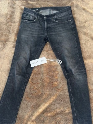 Dondup jeans - Snygga svarta skinny jeans från Dondup med slitna detaljer och klassisk femficksmodell. Jeansen sitter lite större än vad dem borde. Köpta på nkför 3499kr
