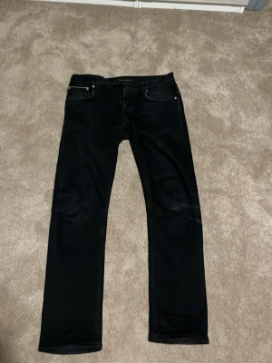 Svarta selvedge Nudie jeans - Svarta nudie jeans, Grim Tim selvedge. Har använts 1 gång och är i storlek 33/30. Priset är diskuterbart