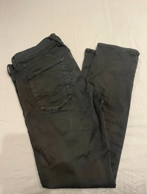 Replay Anbass svarta jeans slim fit - Svarta Replay Anbass jeans med slim fit och klassisk femficksdesign. Snygga detaljer med Replay-logga på fickan och robust dragkedja. Jeansen har en modern, smal passform och är tillverkade i mjukt jeansmaterial med lite stretch för extra komfort.pris kan diskuteras, byxorna har dock färgat av sig på framsidan av byxorna.